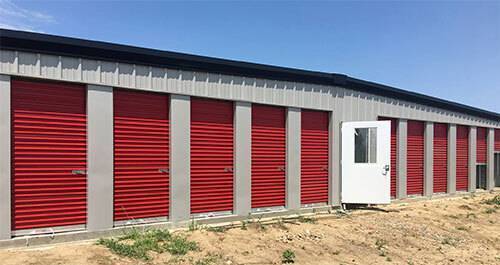 outdoor single-story, metal storage facility with red doors.