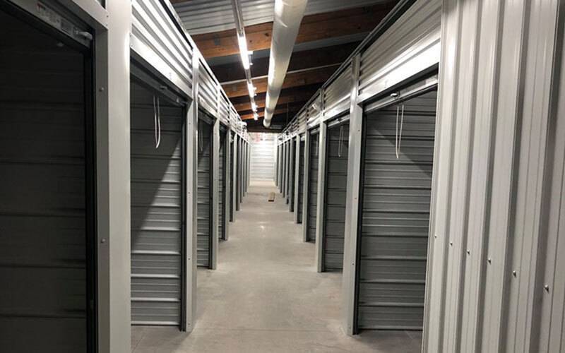 a look down the aisle of an indoor storage unit facility